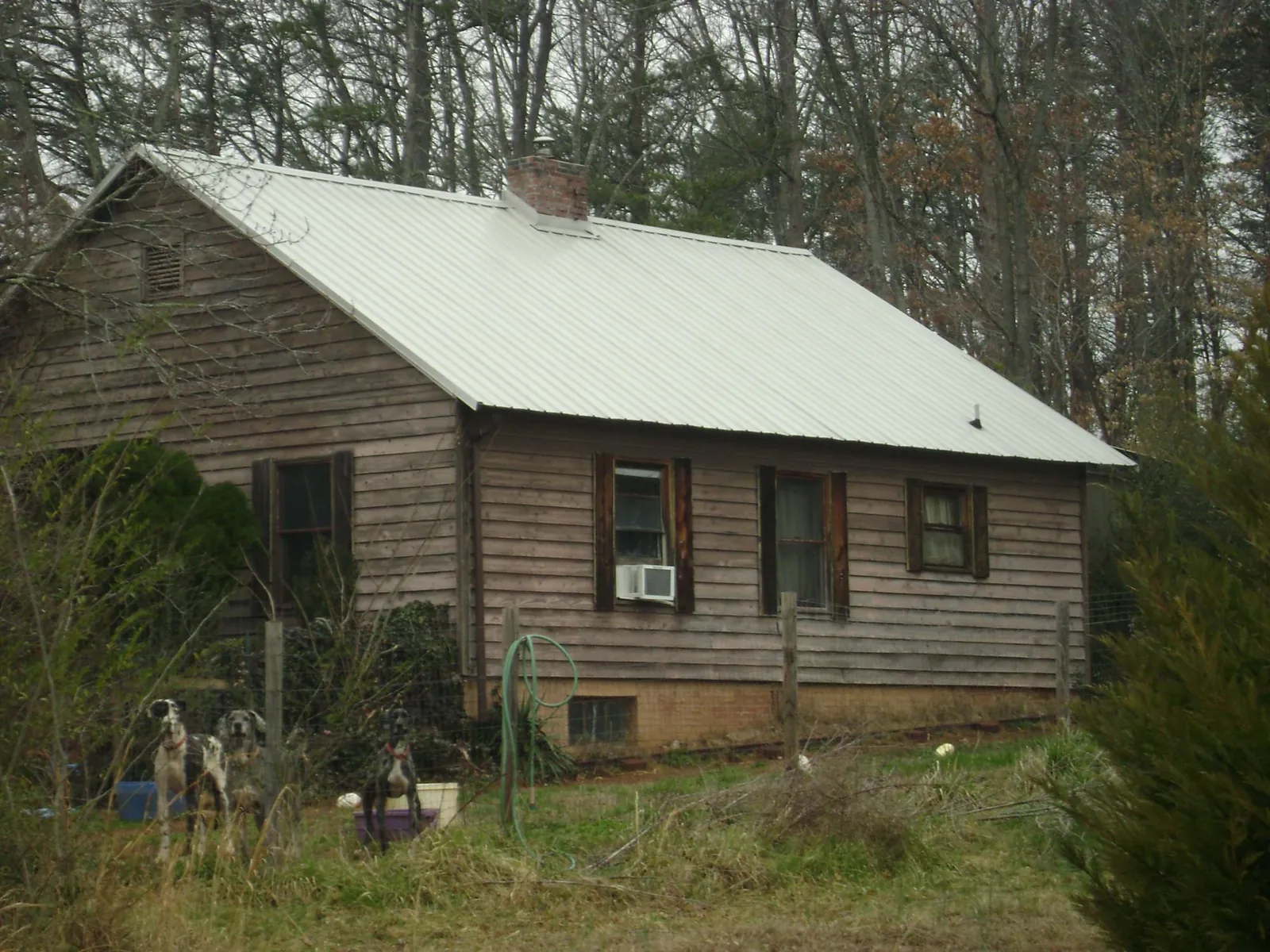 White metal roof on an old wood sided farmhouse, from a Metal Roof Installation job in Gladstone